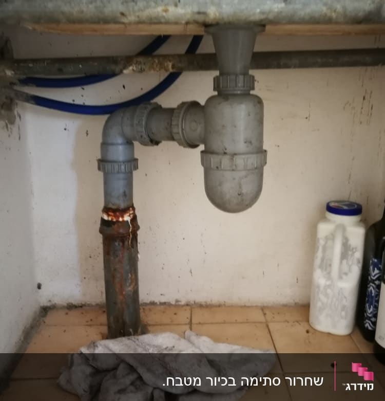 צינור ביוב מתחת לכיור עם חיבורי פלסטיק
